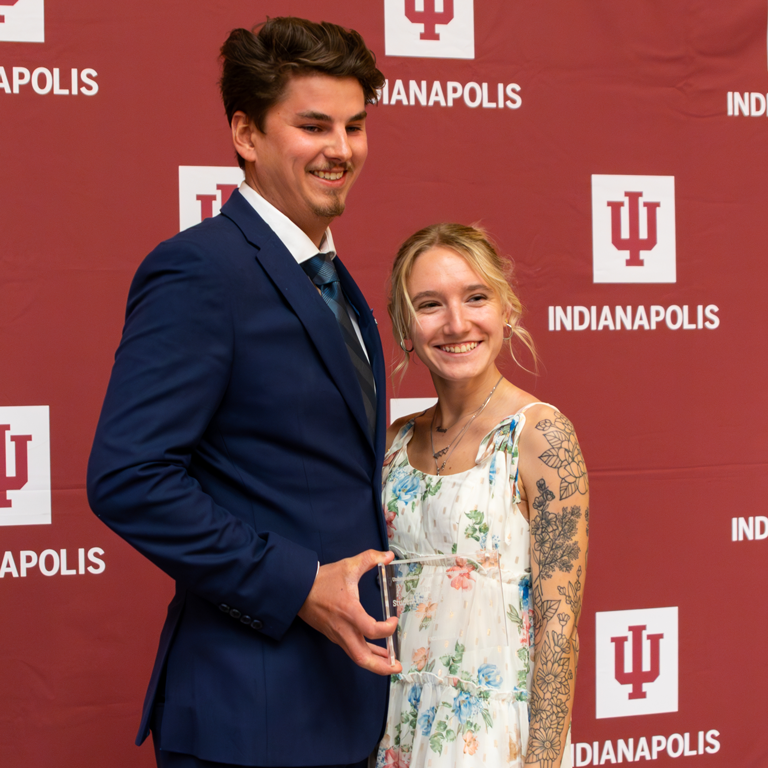 A man holding an award standing next to a woman.