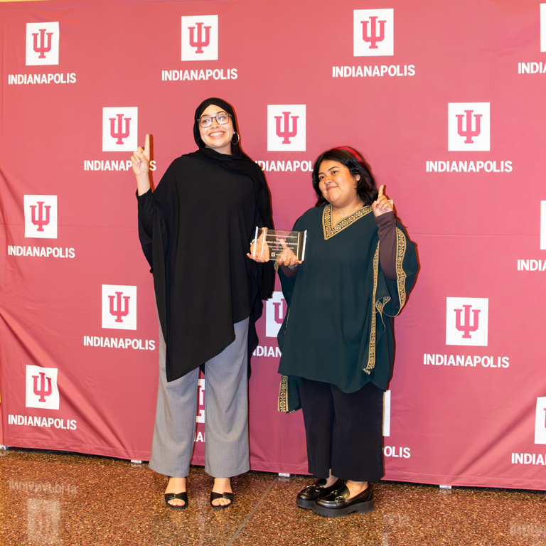 Two women holding up peace signs.